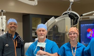 Medical staff stand in an operating room.